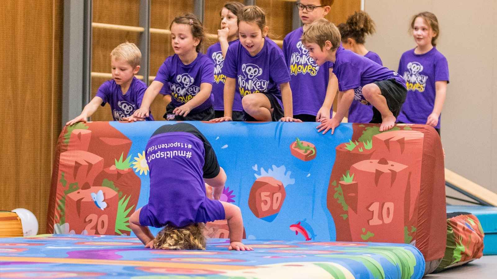 Kinderen leren een koprol tijdens een Monkey Moves les